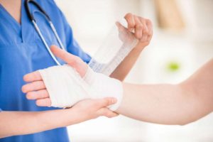 Doctor bandaging person's hand after accident