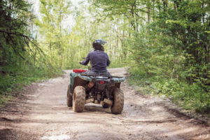 man riding an ATV on a dirt road