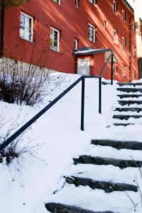 Stairs leading up to an apartment covered in snow