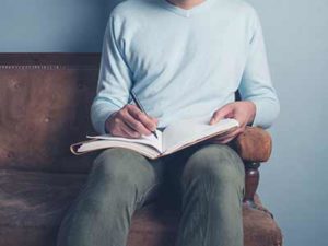 man writing in a journal after being injured in a car accident