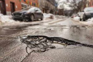 pothole on road in the spring with snow melting