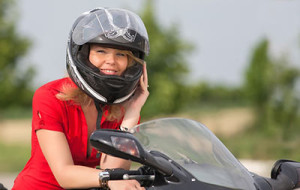 Woman riding motorcycle, abiding by NY motorcycle helmet laws
