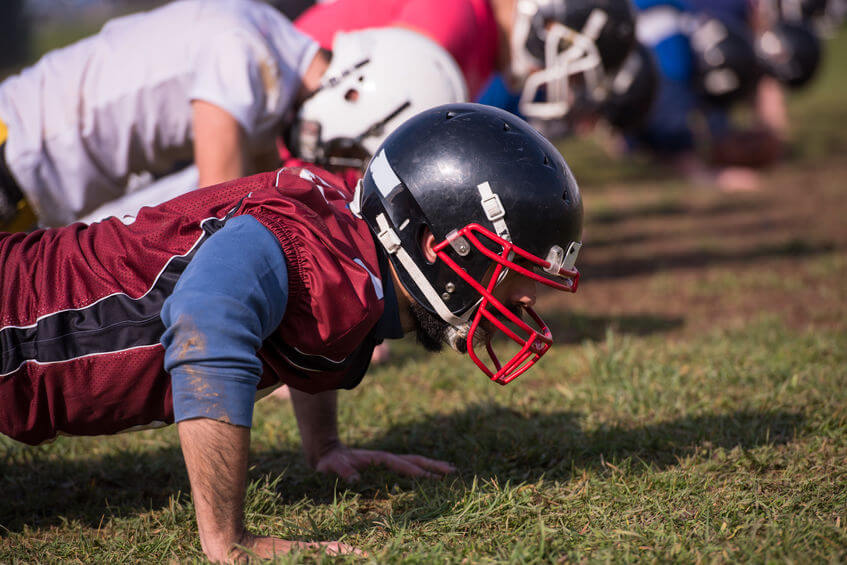 Football players doing exercises after sports injury