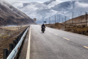 Man riding motorcycle in winter avoiding road hazards